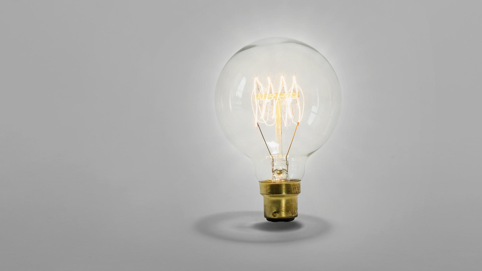 Retro globe light bulb suspended and lit 