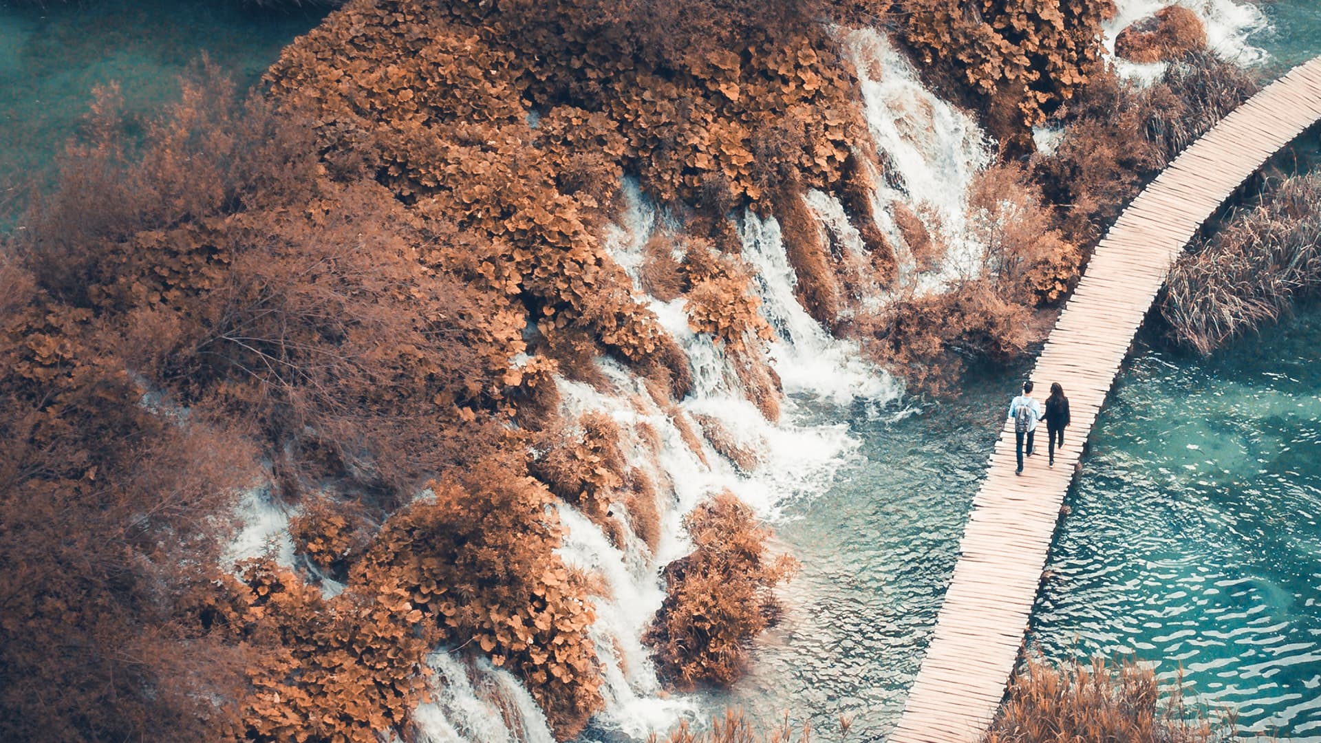 Couple walking hand in hand at Plitvice Lakes National Park, Croatia. 