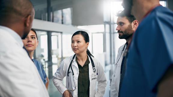 A group of physicians having a serious discussion in a medical setting.