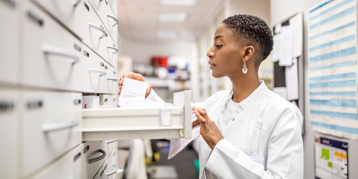 Female pharmacist looking for medicines in the rack
