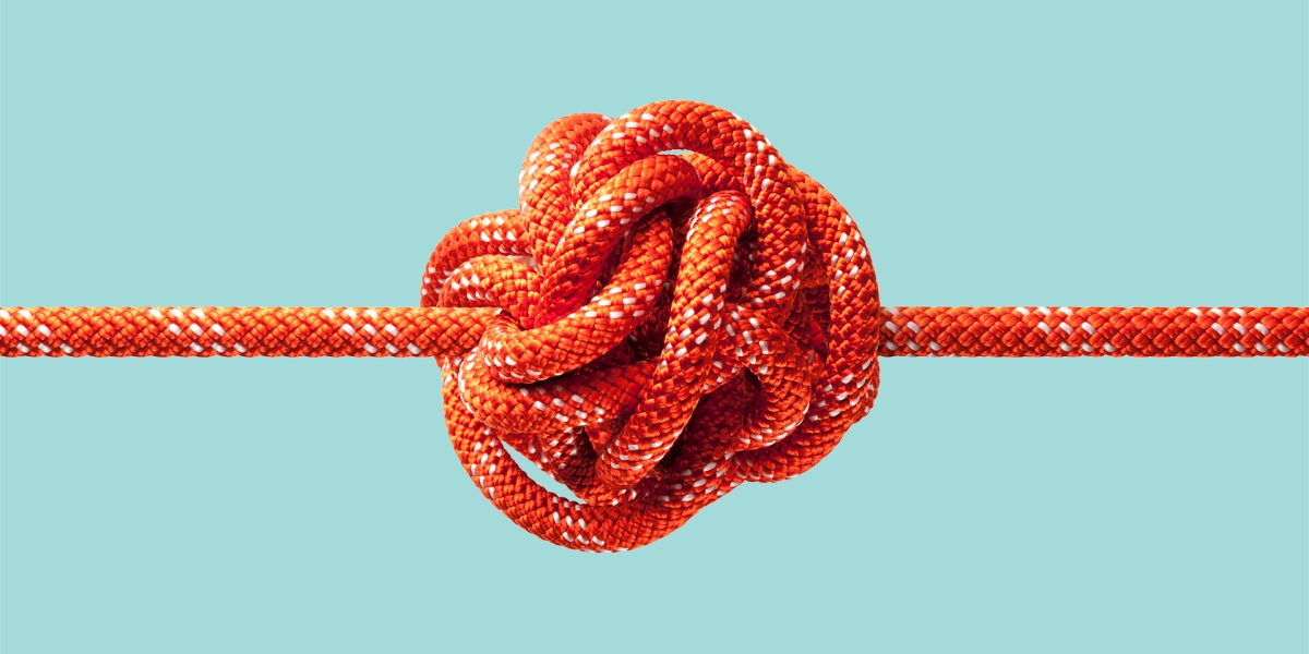 Red rope tied in a large knot in the center with a blue background