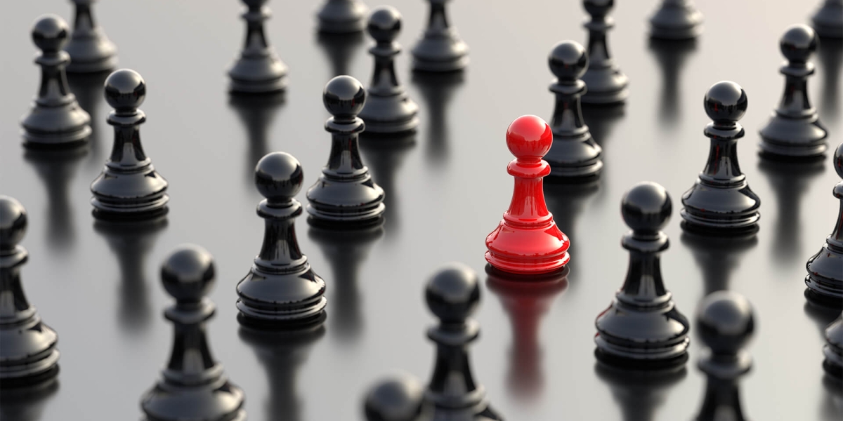 Leadership concept, red pawn of chess, standing out from the crowd of black pawns, on white background