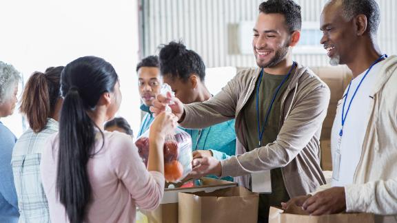A group of volunteers handing out food at a food bank.